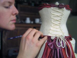 Decorating a wedding cake with corset and fabric